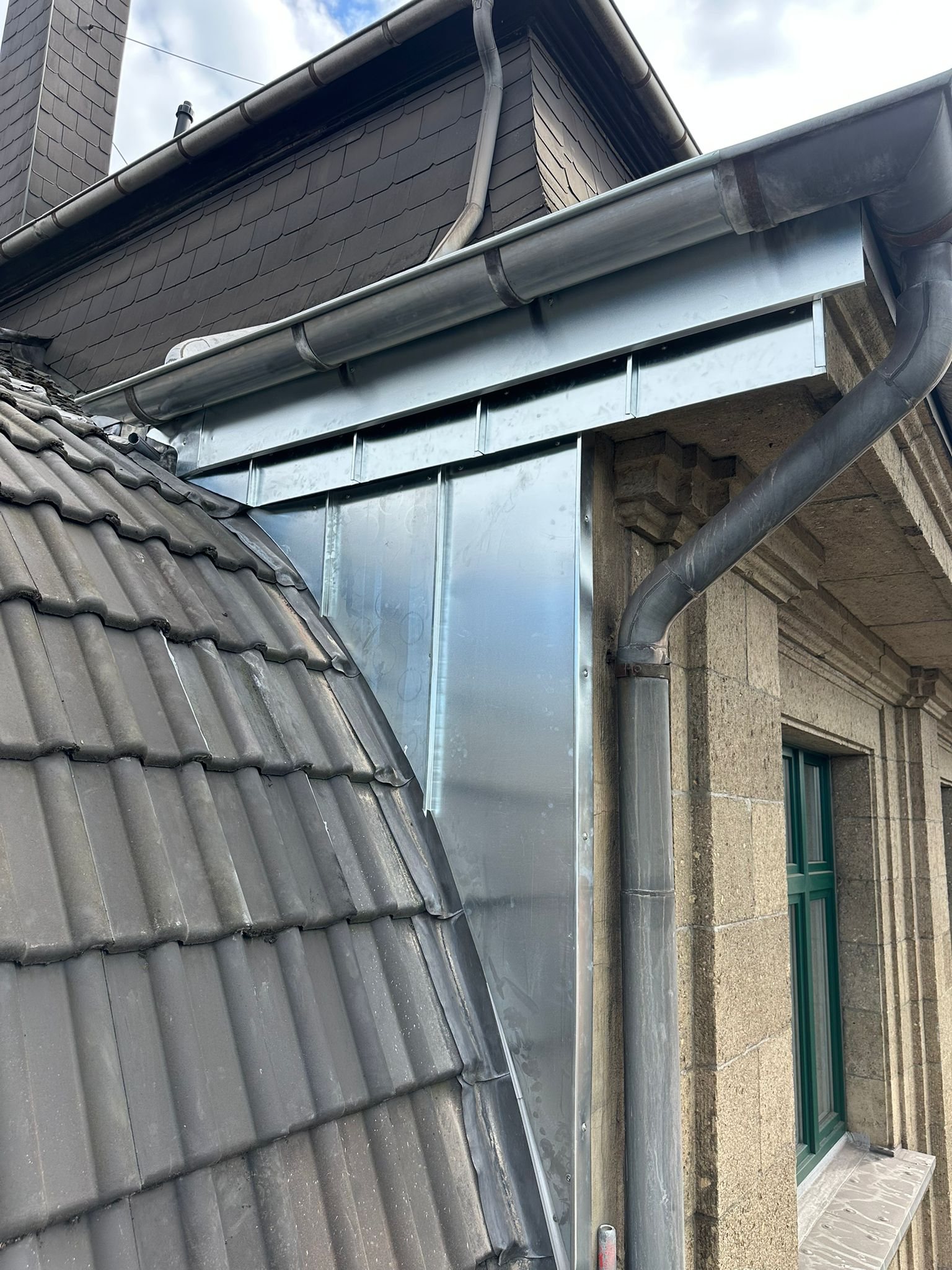 Gerüstarbeiten und neue Blechverkleidung am Dachanschluss bei Wasserschaden